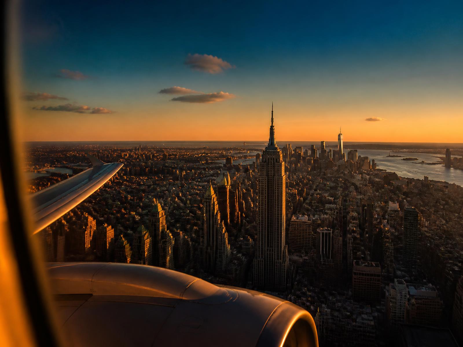 Vista do skyline de Nova York pela janela do avião no fim da tarde
